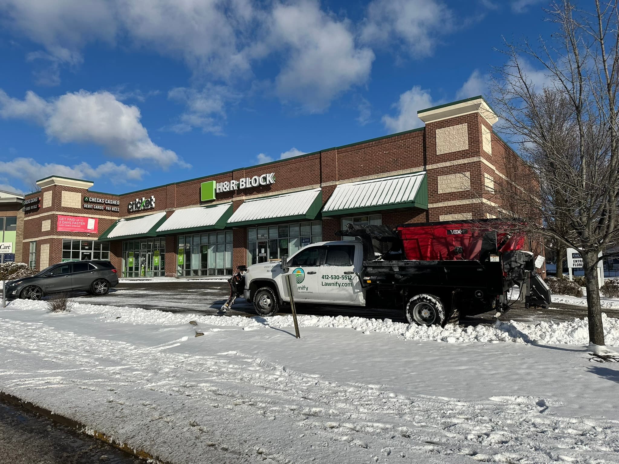 Truck and plow clearing commercial property access lanes